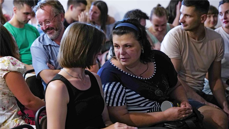 In der Pause spricht Oxana mit ihrer Sitznachbarin über ihre Erfahrungen und die...