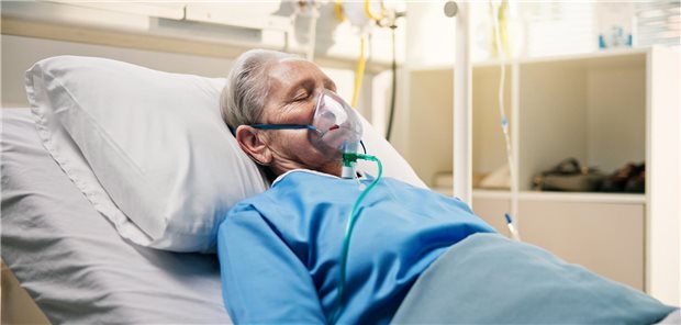 Adjuvantierte und hochdosierte Vakzine schützen wohl besser Ein Mann liegt mit Beatmungsgerät im Bett.