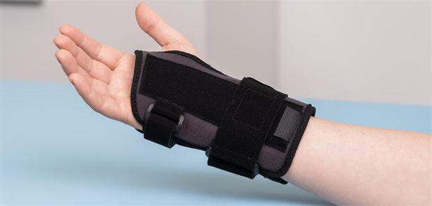 Nahaufnahme des rechten Handegelenks eines Patienten das mit einer Handgelenksschiene ruhig gestellt ist.