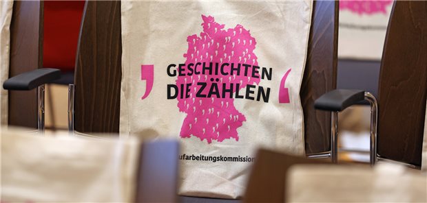 In einer Pause beim Fachgespräch zum Thema „Sexueller Kindesmissbrauch in der DDR – Fokus Sport“ stehen Stoffbeutel mit der Silhouette des DDR-Territoriums mit den Worten „Geschichten die zählen“ auf den Stühlen.