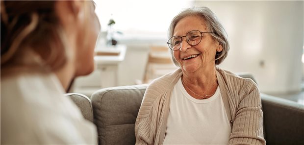Eine Ärztin spricht mit einer älteren Patienten. Die Patientin lächelt. 