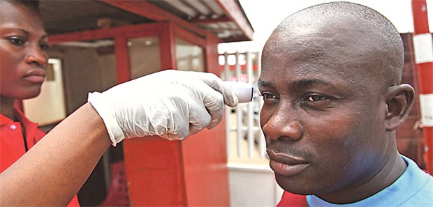 Zeit wird knapp, einen Flächenbrand zu verhindern Infektion mit Ebola? Kontrolle der Körpertemperatur auf dem Weg zur Arbeit in Liberia.