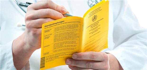 Arzt füllt Impfpass aus