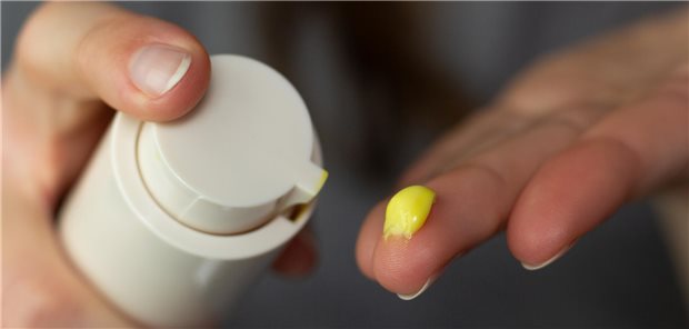 Nahaufnahme einer Frau, die eine Retinol-Creme verwendet.