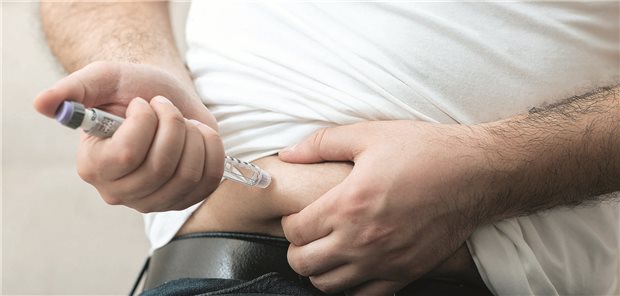 Ein Mann appliziert sich Insulin in den Bauch. 