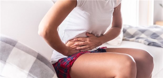 Frau hält sich den Bauch.