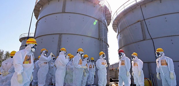 Tickende Zeitbombe Fukushima Japans Premierminister Shinzo Abe (mit rotem Helm) schaut sich die Schäden am havarierten Atomkraftwerk Fukushima an.