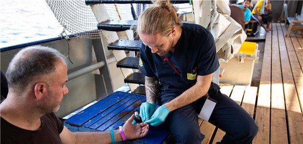 Der erste Einsatz, 60 Gerettete – und ein MedEvac wegen Infarktverdachts Jörg Schmid bei der Versorgung eines Geretteten (die Person hat dem Foto zugestimmt).