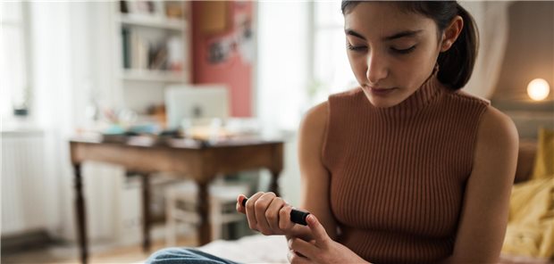 Eine Teenagerin misst ihren Blutzucker.