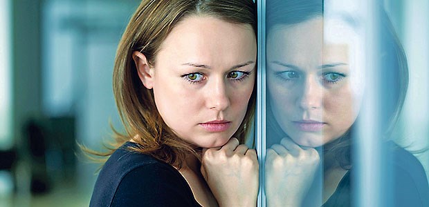 Reform wird Wartezeit auf Psychotherapie nicht verkürzen Junge Frau an einer Fensterscheibe: Junge Menschen leiden besonders häufig an psychischen Störungen.