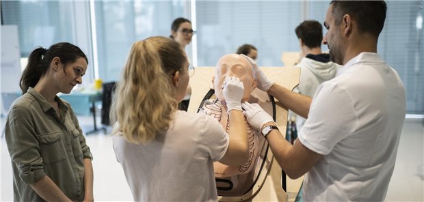 Angehende Ärzte untersuchen einen Patienten-Dummy