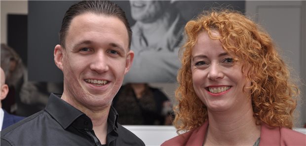 Narben sind ein Teil von ihnen – Fotos von Brandverletzten Justin und die Fotografin Gina Kühn mit Justins Portrait im Hintergrund. So wie er haben sich 17 Menschen von Kühn fotografieren lassen, die als Kind schwere Verbrennungen erlitten haben.