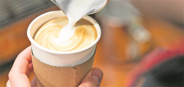Koffein als Trigger früher kryptogener Schlaganfälle? Jemand gießt Milchschaum in einen To-Go-Becher