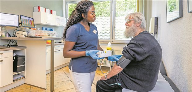 Karinna Pie Blex, MFA, misst den Blutdruck bei einem Patienten.