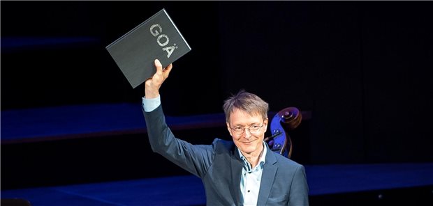 Karl Lauterbach (SPD) hält ein Buch mit den Forderung einer überarbeiteten GOÄ  in der Hand, das ihm bei der Eröffnung des Deutschen Ärztetages 2022 überreicht wurde.