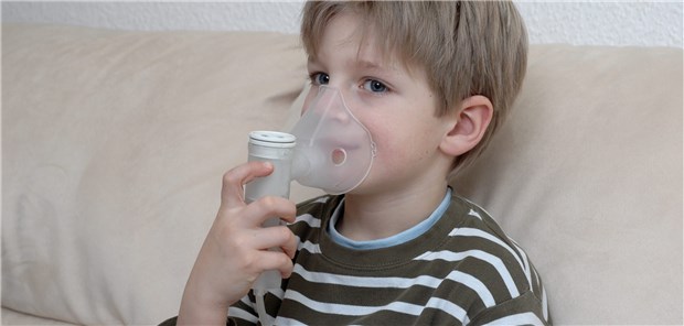 Wann wird Wheezing bei Kindern zu Asthma? Kind mit Inhalator: Dieser lindert die Asthma-Symptome.