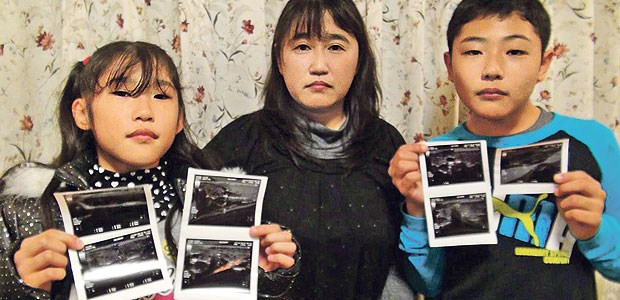 Streitpunkt Schilddrüsenkrebs Kinder aus der Präfektur Fukushima zeigen ihre Befunde der Ultraschalluntersuchung der Schilddrüse.