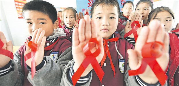 Sex-Tabu bremst Aufklärung Kinder im Dorf Linian sollen früh sensibilisiert werden für ein verdrängtes Thema: Sie zeigen rote Aids-Schleifen als Zeichen der Solidarität.