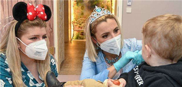 Wo Eiskönigin Elsa Zähne bohrt Kinderzahnärztin Dr. Anne Heinz (Mitte), verkleidet als Eiskönigin Elsa, und ihre Arzthelferin Ari Dema mit ihrem zweijährigen Sohn Diar in der Kinderzahnarztpraxis „Dentiland“.