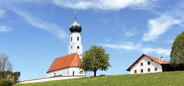 Jetzt wird um den Kirchturm geblickt Kirchturm in Bayern: Wie um ihn herum die medizinische Versorgung strukturiert ist, wird noch erforscht.