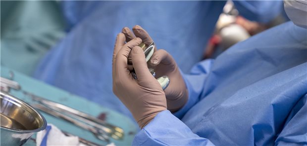 Ein künstliches Kniegelenk wird während einer Kniegelenks-Op zum Einsetzen mit Knochenzement vorbereitet.