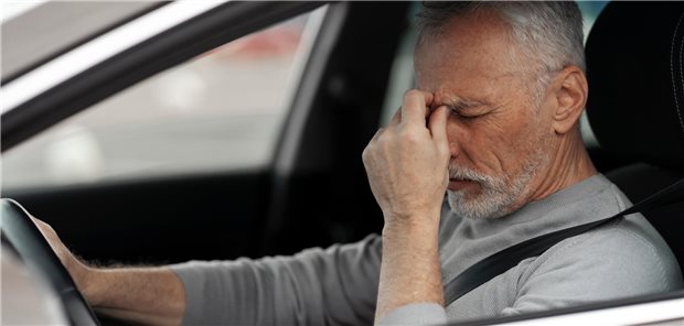 Mann mit Kopfschmerzen im Auto