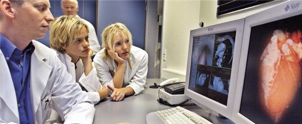 Task Force für Erwachsene mit Herzfehlern Kollegen begutachten CT-Bilder eines Patienten, der eine Herzuntersuchung bekommen hat.