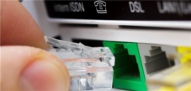 KBV fordert „staatliches TI-Netz“ und Digital-Moratorium Ein Netzwerkkabel wird in einem Router in den Anschluss fuer IP-Telefonie gesteckt