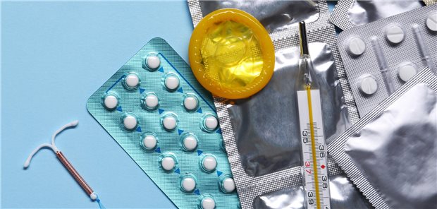 Verschiedene Verhütungsmittel liegen auf einem blauen Hintergrund