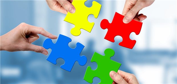 Hände mit ineinanderpassenden Puzzleteilen