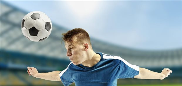 Ein Fußballspieler macht einen Kopfball. 