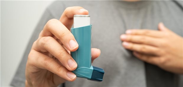 Ein Mensch hält einen Inhalator in dr Hand.