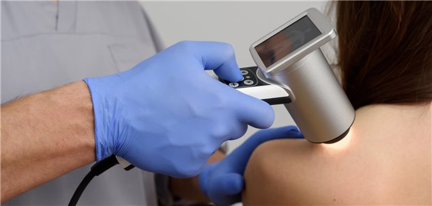 Nahaufnahme wie ein Dermatologe die Muttermale des Patienten mit einem Dermatoskop untersucht. 