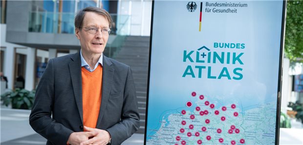 Karl Lauterbach vor einem Schild des "Klinik-Atlas"