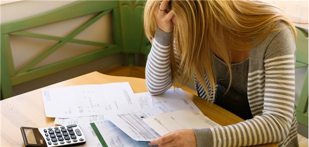 Erst Krebsdiagnose, dann arm? Finanzrisiko Tumorerkrankung Verzweifelte Frau grübelt über Rechnungen.