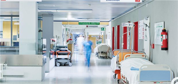 Notaufnahme eines Krankenhauses. Verschwommen sind zwei gehende Personen im Flur zu erkennen.