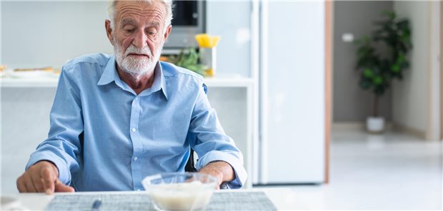 Ein dünner Mann vor einer Schüssel mit Essen.