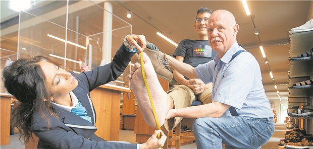Wenn ein Riese neue Schuhe braucht Lucia Sinigagliesi, Richterin des Guiness-Buch der Rekorde, und Schuhmacher Georg Wessels von der ÜbergrößenSchuhwerkstatt Wessels, vermessen den rechten Fuß von Jeison Rodriguez.