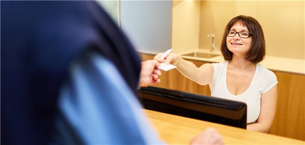 MFA gibt einem Patienten Gesundheitskarte zurück.