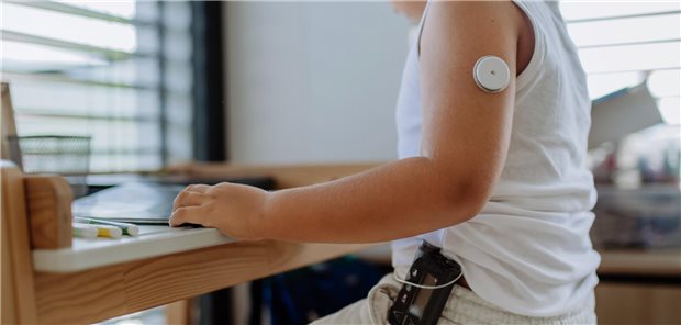 Ein Junge sitzt an einem Schreibtisch und macht seine Hausaufgaben. Er nutzt ein Closed-Loop-System.