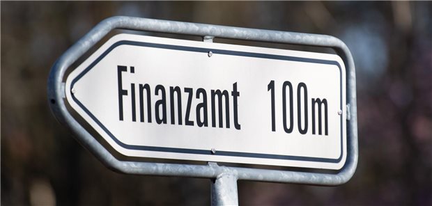 Straßenschild mit der Aufschrift "Finanzamt 100m"