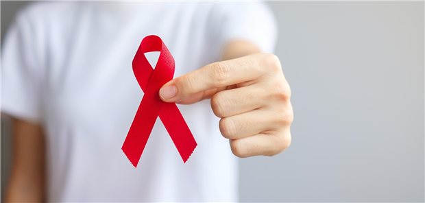 Ein Mann hält eine Aids-Schleife in die Kamera.