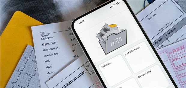 Ein Smartphone auf dem gerade eine elektronische Patientenakte angezeigt wird, liegt auf medizinischen Dokumenten