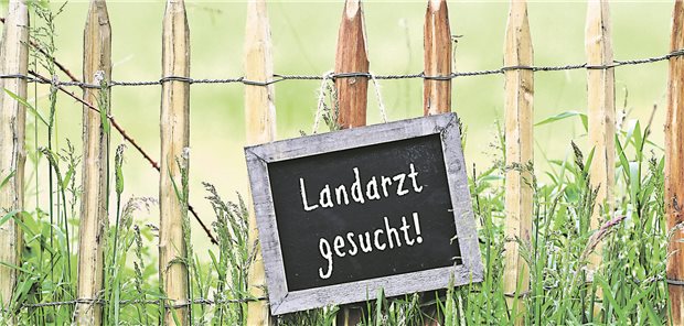 Schild an einem Zaun mit der Aufschrift "Landarzt gesucht!"