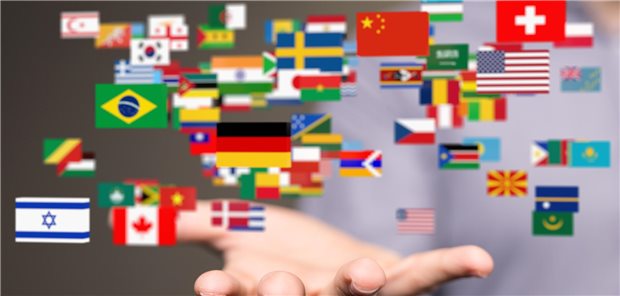 Ein mann hält seine Hand offen. Aus der Hand kommen die Flaggen verschiedener Länder geflogen.  