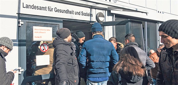 Impfstelle für Flüchtlinge soll Masern-Welle eindämmen Menschen warten vor dem Landesamt für Gesundheit und Soziales in Berlin. Dort ist die zentrale Impfstelle für Flüchtlinge geplant.