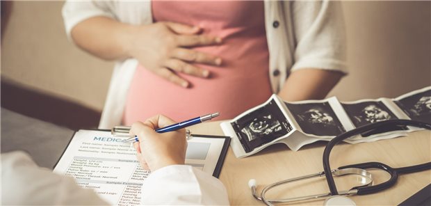 Eine schwangere Frau besucht einen Gynäkologen im Krankenhaus oder in einer medizinischen Klinik für eine Schwangerschaftsberatung.