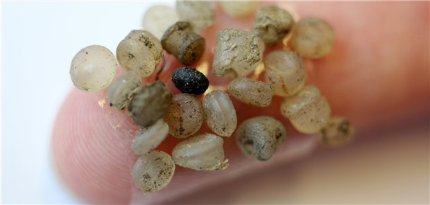 Leise rieselt das Mikroplastik Mikroplastik-Teilchen kleben an einem Finger.