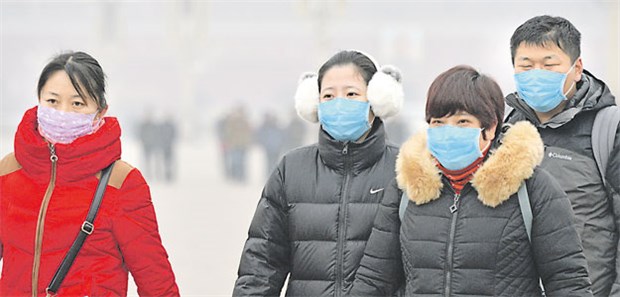 Smog-Alarm legt Pekinger Alltag lahm Mit Atemmaske unter der grauen Dunstglocke: Zwei Besucherinnen des Pekinger Tiananmen-Platzes am Dienstagmittag.
