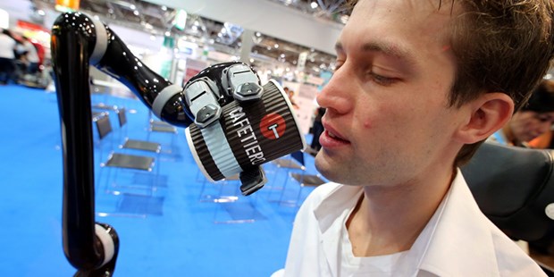 Roboter, hol mir Bier! Mit Hilfe des "JACO" Roboterarms trinkt Tom auf der Rehacare in Düsseldorf einen Becher Kaffee.